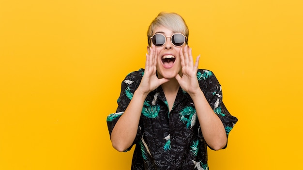 Young curvy woman wearing a summer look shouting excited to front.