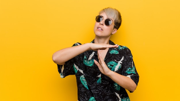 Young curvy woman wearing a summer look showing a timeout gesture.