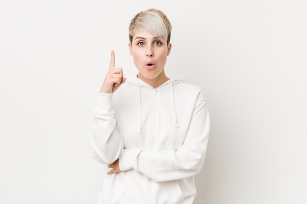 Young curvy woman wearing a white hoodie having some great idea, concept of creativity.