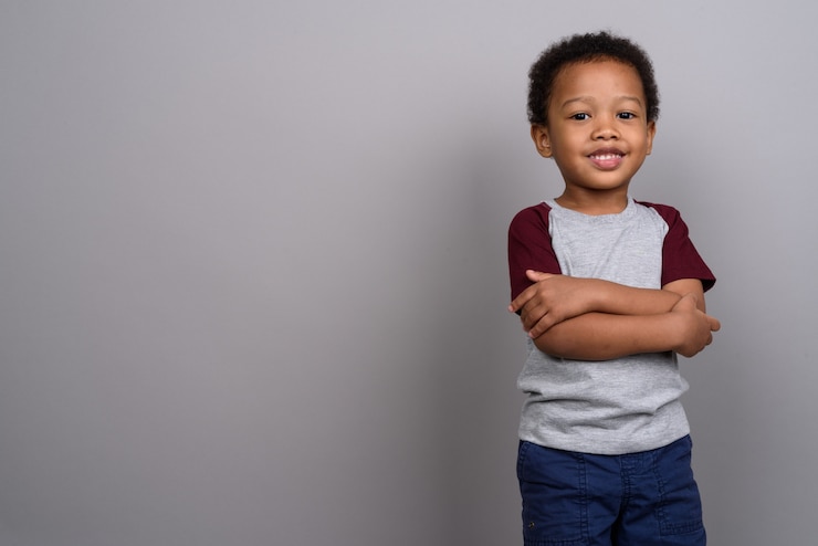 Photo young cute african boy against gray wall
