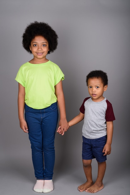 Young cute African brother and sister holding hands