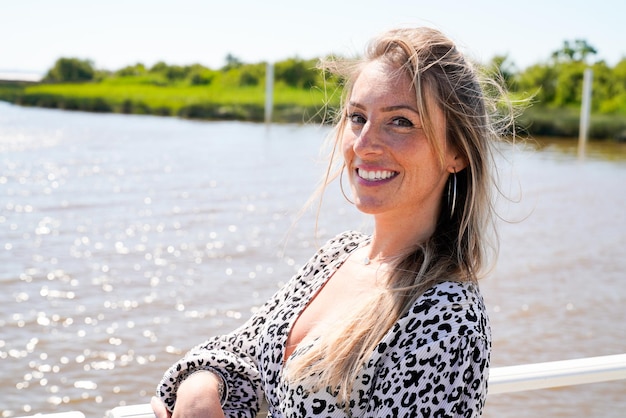 Young cute beautiful woman smiling happy enjoying summer vacation on harbor sea beach