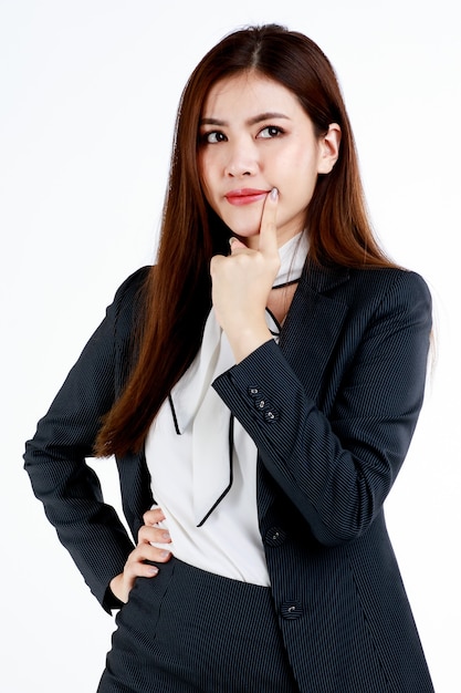 Young and cute businesswoman pose in thinking gesture by using finger touch cheek and look high above.