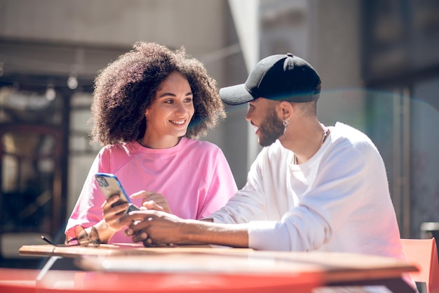 Photo young cute couple sitting together and watching something on internet