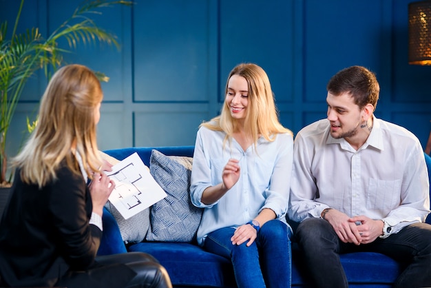 young cute family on the meeting with realtor, interior designer, decorator.