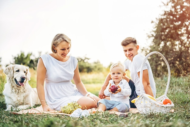 Young cute family on picnic with dog