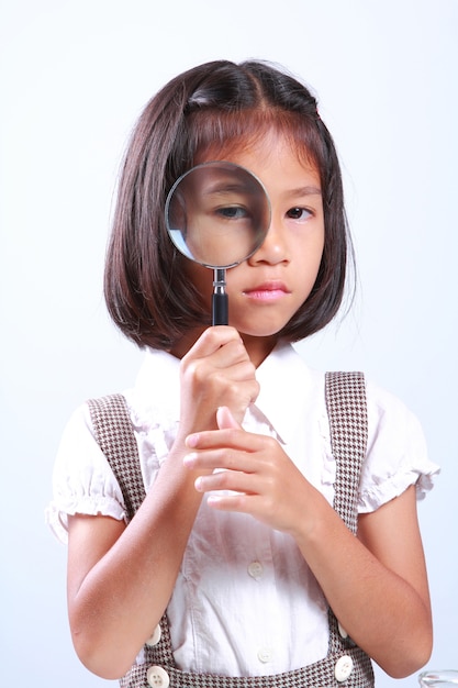 Young cute girl holding magnifying glass