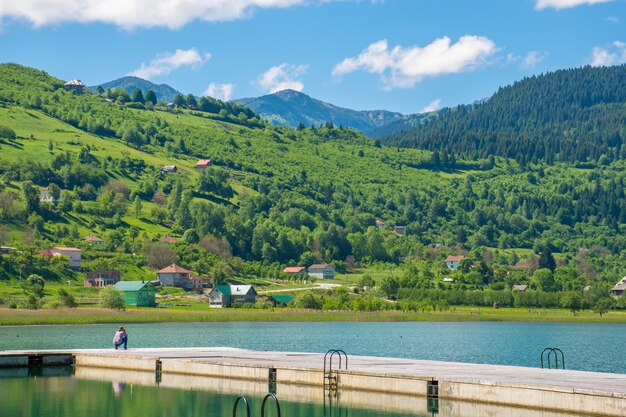 Photo young cute girl photographer walking on a mountain lake.