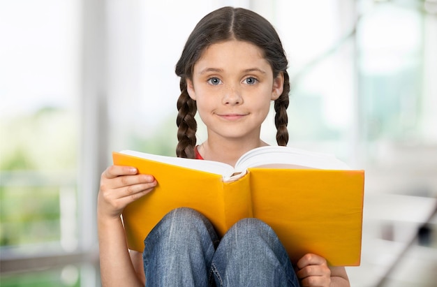 Young cute girl reading book