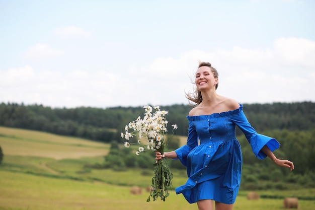 Young cute girl run in a field at sunset