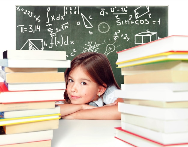 Young cute girl sitting at the table and reading a book