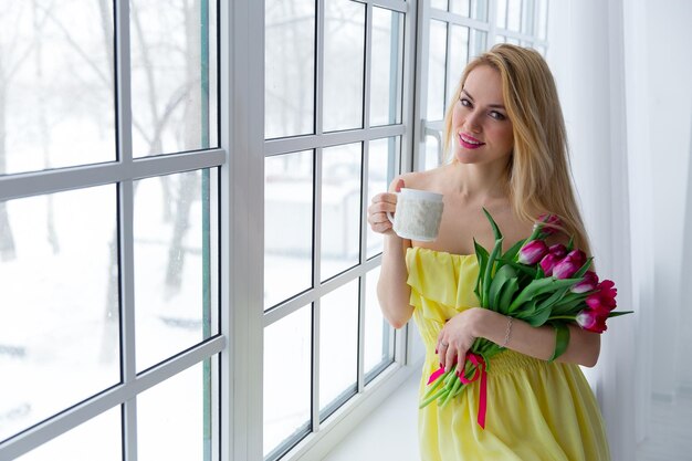 Young cute girl with pink tulip bouquet 8 march international womens day