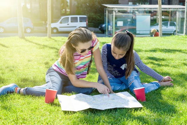 Young cute girls teens with map of european city outdoors