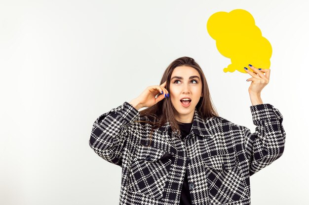 Young cute lady holding talking box and thinking on white background