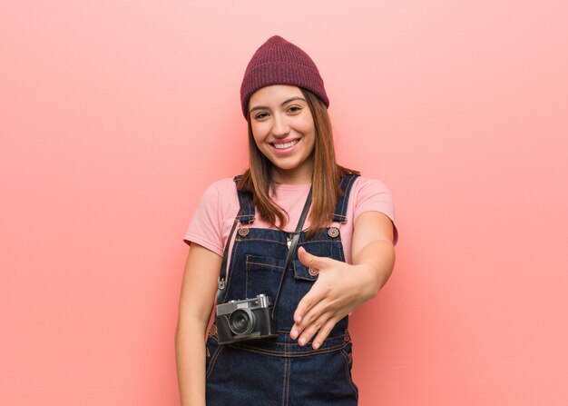 Young cute photographer woman reaching out to greet someone