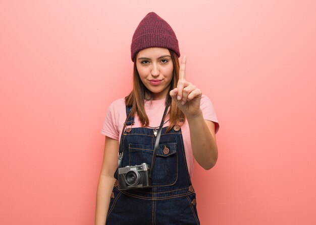 Young cute photographer woman showing number one