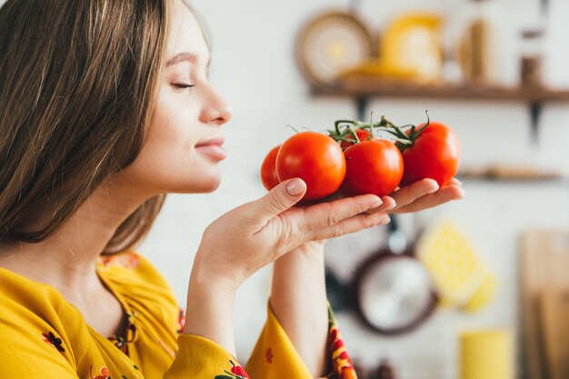 Foto giovane ragazza incinta carina che prepara insalata di verdure in cucina