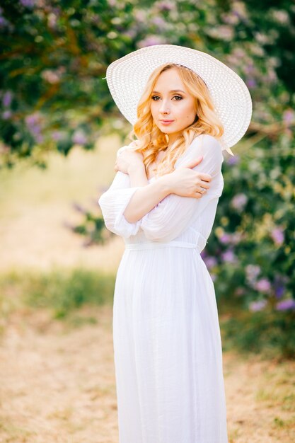 Young cute pretty blonde amazing model girl in white dress portrait in park outdoor. 