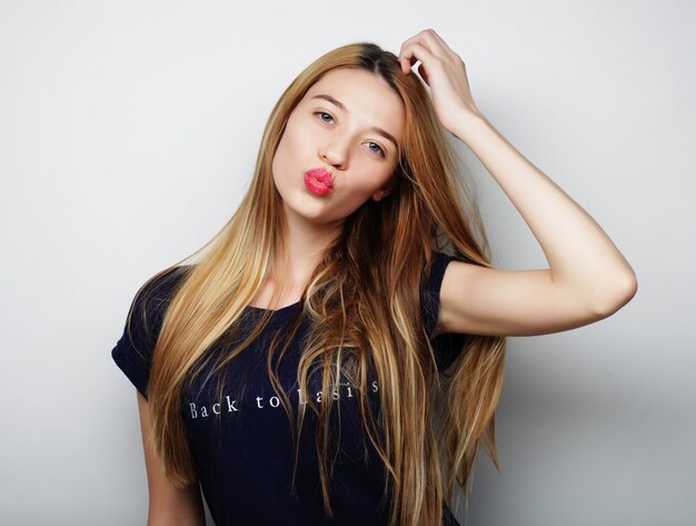 Young cute smiling blond girl over white background