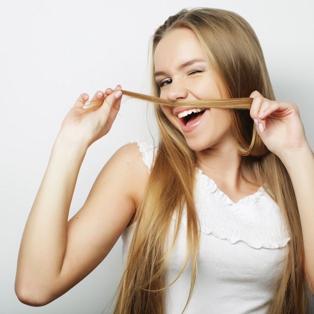 Young cute smiling blond girl on white background