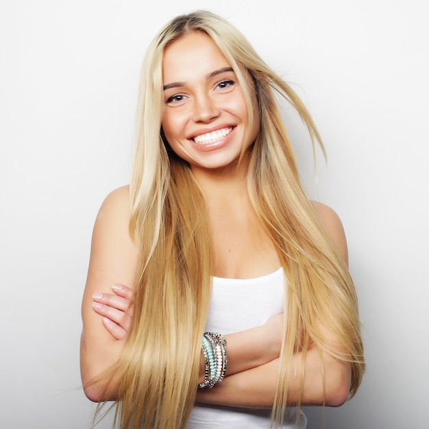 Young cute smiling blond girl on white background