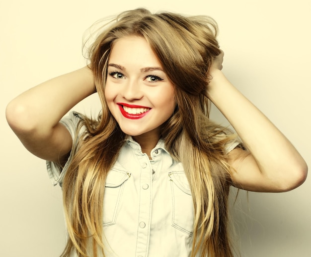 Young cute smiling blond girl on white background