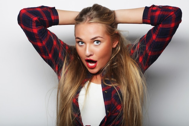 Young cute smiling blond girl over white wall