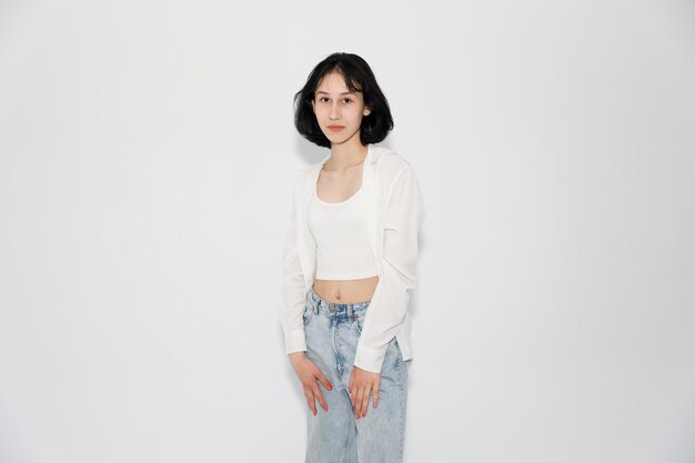 Young cute teen girl in jeans and shirt on a white background