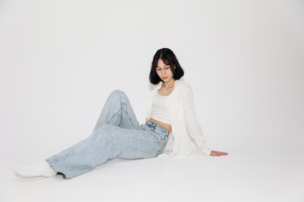 Young cute teen girl in jeans and shirt on a white background