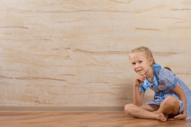 Young Cute White Girl, Sitting on Floor, Isolated on Wooden Walls