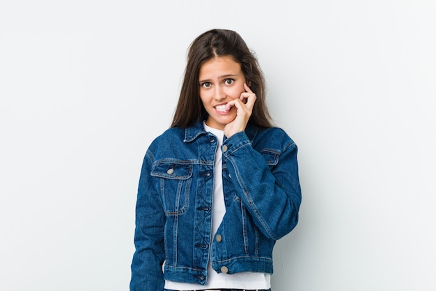 Young cute woman biting fingernails, nervous and very anxious.