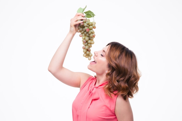 Young cute woman eating grapes