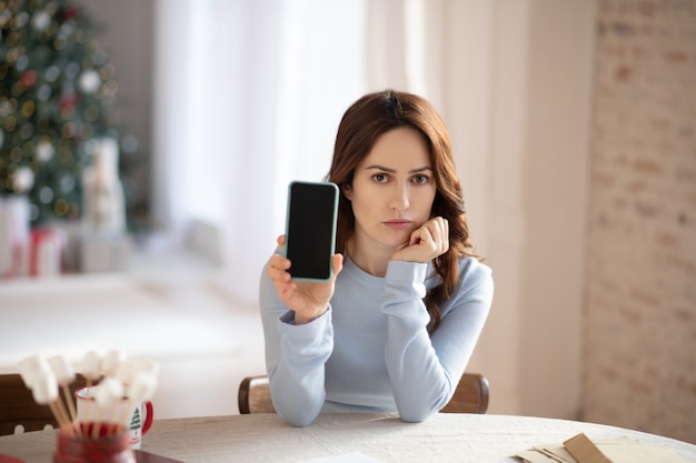 Young cute woman in grey sweater feeling sad