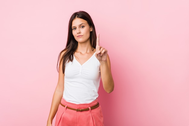 Young cute woman showing number one with finger.