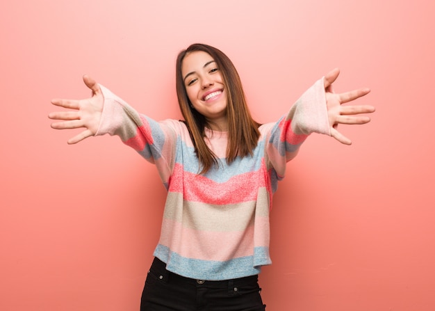 Young cute woman very happy giving a hug to the front