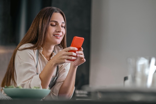 手にスマートフォンを持つ若いかわいい女性