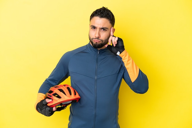 Young cyclist arab man isolated on yellow background thinking an idea