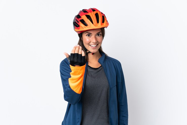 Photo young cyclist brazilian girl isolated on white  background inviting to come with hand. happy that you came