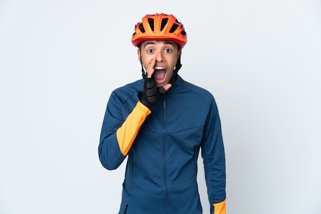 Young cyclist Brazilian man isolated on white wall shouting with mouth wide open