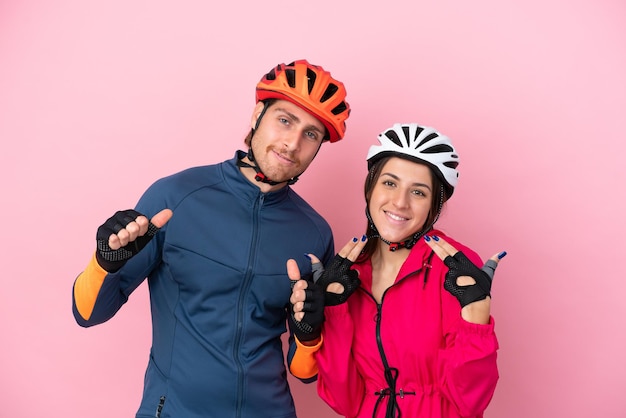 Young cyclist caucasian people isolated on pink background proud and self-satisfied in love yourself concept