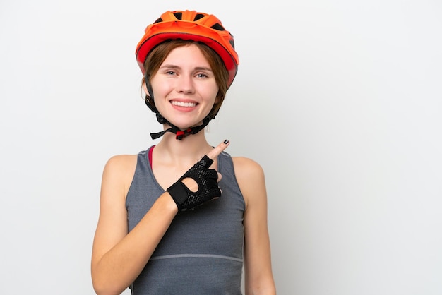 Young cyclist English woman isolated on white background pointing to the side to present a product