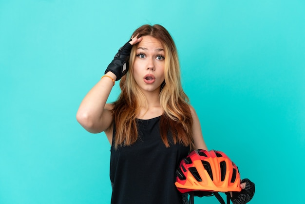 Молодая велосипедистка на изолированном синем фоне кое-что поняла и намеревается решить