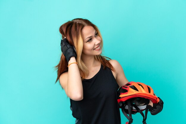 Young cyclist girl over isolated blue background thinking an idea