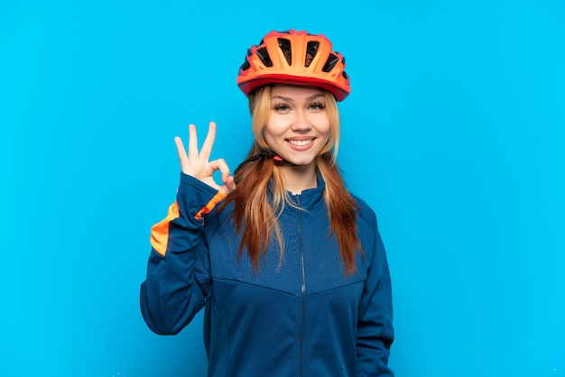 Ragazza giovane ciclista isolata che mostra segno giusto con le dita