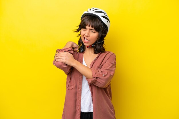 Young cyclist latin woman isolated on yellow background