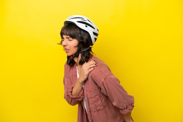 Young cyclist latin woman isolated on yellow background