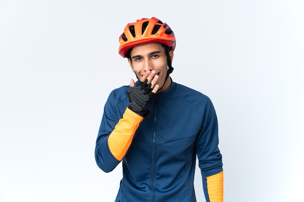 Young cyclist man isolated on background happy and smiling covering mouth with hand