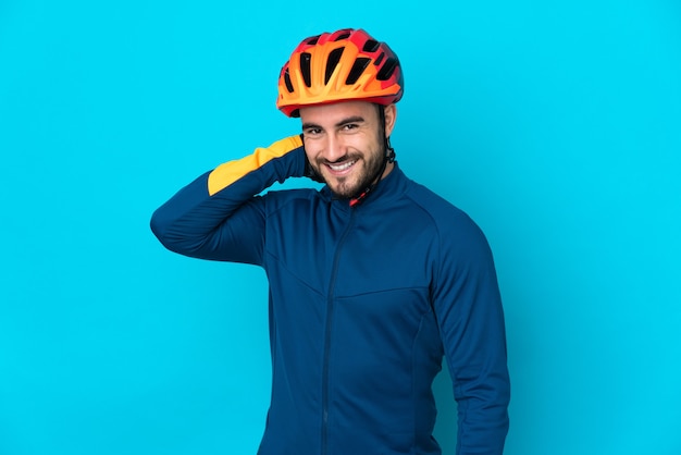 Young cyclist man isolated on blue background laughing