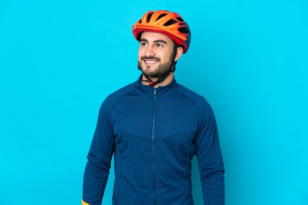 Young cyclist man isolated thinking an idea while looking up