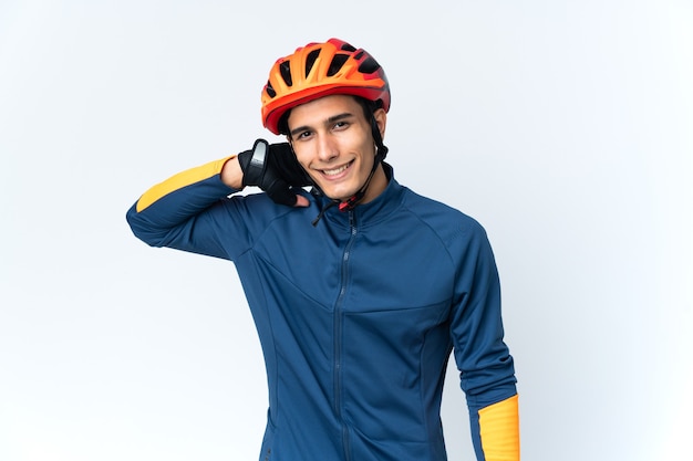 Young cyclist man isolated on wall laughing